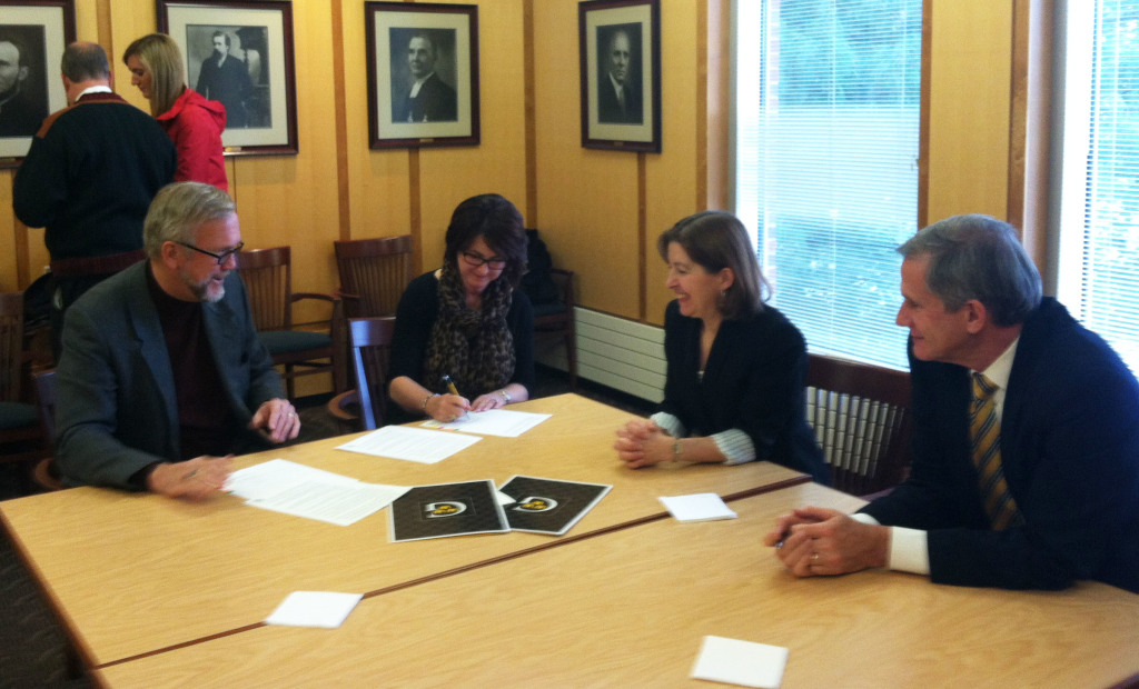 Bob and Cindy Peterson sign the official paperwork for the Robert A. Peterson Distinguished Student Scholarship Fund alongside President Bergman and Vice President for Finance Ken Westphal