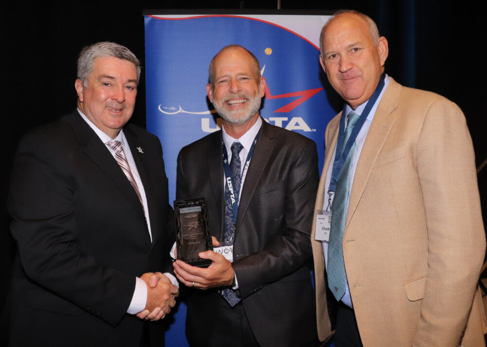 Neal Hagberg (center) with USPTA leadership after receiving community service award